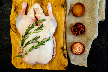 Raw whole duck, spices: mix pepper, himalayan pink salt and honey, rosemary, sackcloth. Top view. Space for text. Everything you need to make Peking Duck.