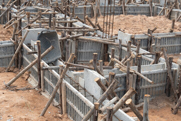 Block formwork for house beams with supported by wooden logs. Construction of the foundation of the house on the ground during the day time.