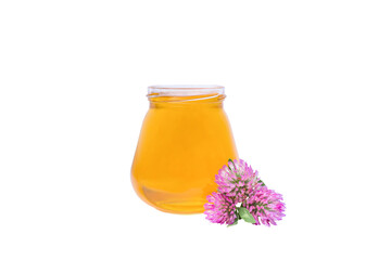 on a white background, a jar with honey and a piece of beeswax and a clover flower
