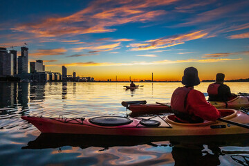 Sea kayakers looking east across Toronto's Inner Harbour just as the rising sun breaks the horizon...
