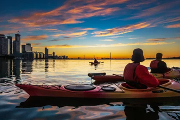 Foto auf Acrylglas Sea kayakers looking east across Toronto's Inner Harbour just as the rising sun breaks the horizon over the Portlands area. Shot in summer.  Room for text. © Michael Connor Photo