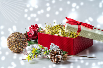 Christmas gift box and new year decorations under white blurred background.
