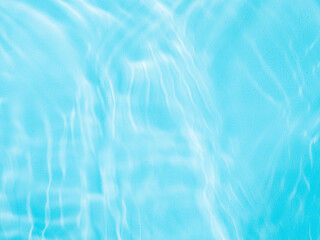 Ripple water texture on blue pool background. Shadow of water on sunlight. Mockup for product, spa or travel background. Marble blue water surface as wallpaper background