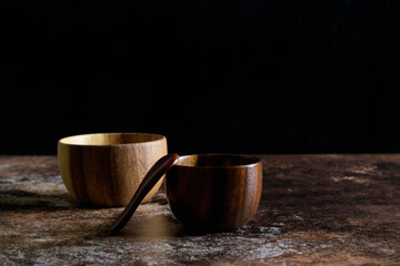 Two japanese style wooden bowl with wooden spoon on dark grunge brown background with copy space, still life minimalist composition