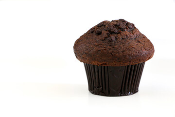 A delicious and irresistible double chocolate muffin cake on right of frame isolated against white background