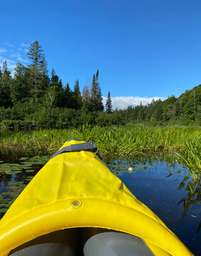 Kayak gonflable sur un lac paisible l'&eacute;t&eacute;. Pointe d'un canot jaune sur une rivi&egrave;re entour&eacute;e de montagnes et d'arbres. Pagayer sur l'eau calme. 