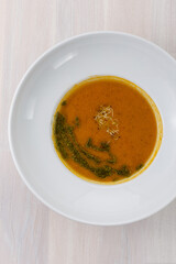 carrot soup with microgreens and green oil on the table top view