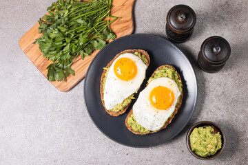 Two avocado open sandwiches with egg. Keto and diet concept. Healthy toast food for breakfast.