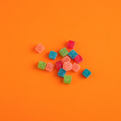 Sweet jelly candies on orange colored foami background