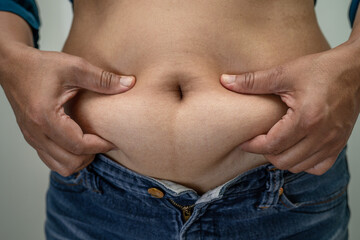 Naklejka premium Overweight Asian woman show fat belly at office.