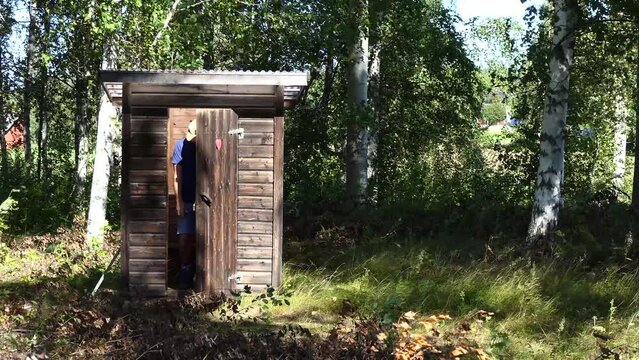 Skellefteå, Sweden A man uses an outhouse to go to the toilet.
