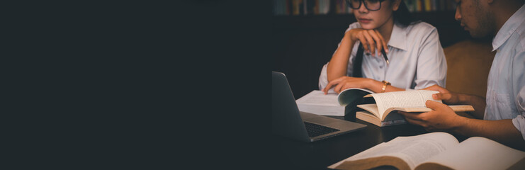 Group of Diversity Student study and reading book together in library at asian college. Happy multi...