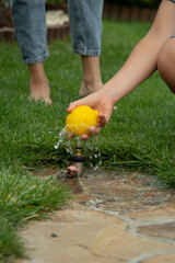 girl washes lemons, under running water, a hand and lemon