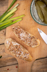 Sandwiches with rillettes, meat pate on a wooden cutting board. Rustic composition with spread meat product, top view.