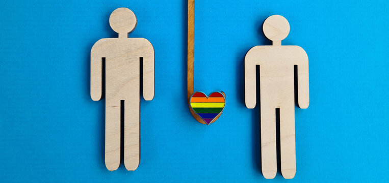 Gay lgbt protection and safety wooden figures under umbrella.