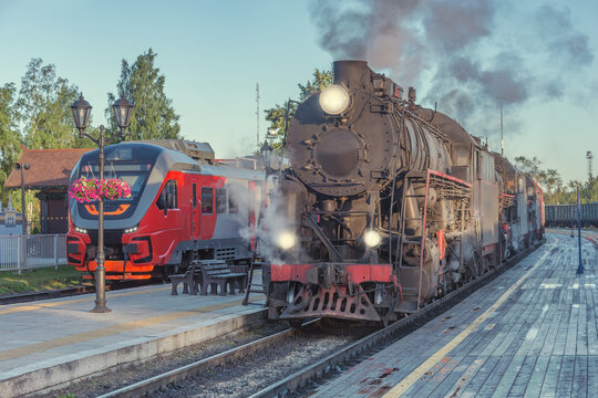 Steam locomotives stand by the wooden platform. © serjiob74