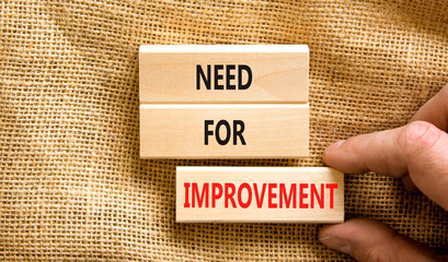 Need for improvement and support symbol. Concept words Need for improvement on wooden blocks. Businessman hand. Beautiful canvas background. Business, need for improvement quote concept. Copy space.