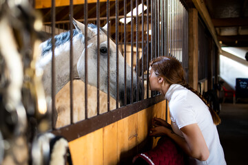 Portrait of a girl preparing her horse for riding.