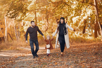 Fototapeta premium Family with little daughter in a autumn park
