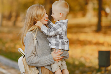 Mother with little son playing in a autumn field