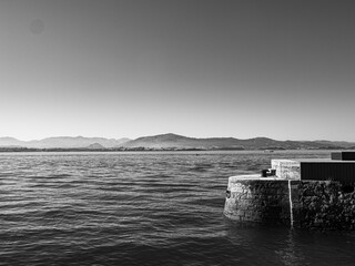 Black and white view of stone wall on the coast of Santander
