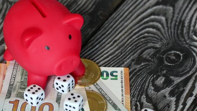 Piggy bank among dollar and euro banknotes. Cryptocurrency coins are visible. Multicurrency savings. Risk while saving money. Camera zoom.