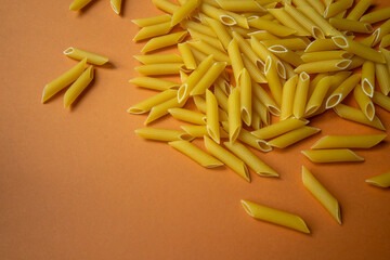 raw pasta on a yellow background close-up, space for a slogan