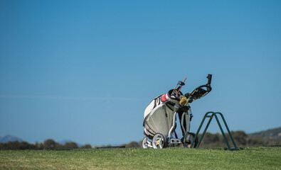 Golf bag and equipment at a golf academy. Blue sky background.