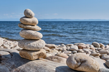 Fototapeta na wymiar Pyramid of stones on shore of Barguzin Bay, Lake Baikal, Zabaikalsky National Park, Russia.