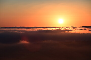 sunrise over clouds and town