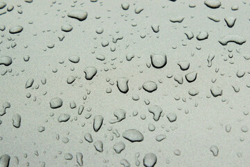 Background - raindrops on the metal surface of a modern car
