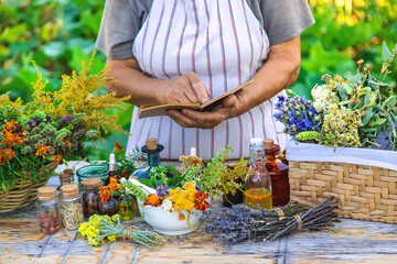 Grandmother makes tinctures from medicinal herbs. Selective focus.