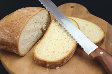 Bread Knife Slicing Through a Loaf. Cut fresh bread with a knife.