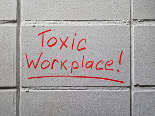 Toxic workplace words handwritten on the wall.