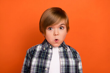 Photo of young impressed boy panic fake gossip information staring isolated over orange color...