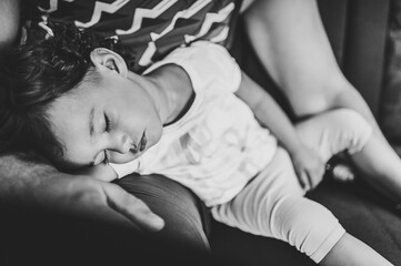 Close up father hands holding baby. Dad holds his daughter, who is sleeping in his arms.  Black and white photo.