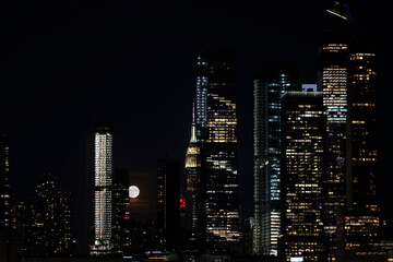 Panoramic view New York City Manhattan Hudson Yard skyscrapers and bright full moon behind...