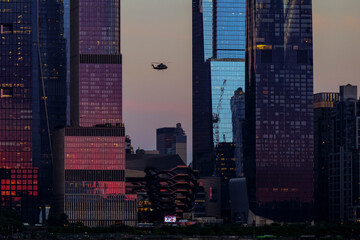 Fototapeta na wymiar View to Manhattan skyline Hudson Yards skyscrapers and helicopter on the front, from Weehawken Waterfront in Hudson River at sunset. High quality photo
