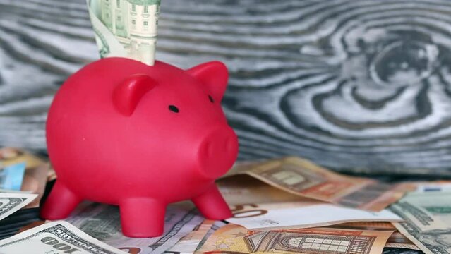 Piggy bank on dollar and euro banknotes. Next to the dice. Multicurrency savings. Risk while saving money_