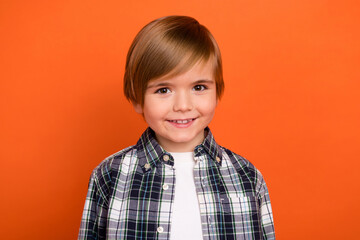 Photo of young cheerful little boy toothy smile wear modern outfit isolated over orange color background