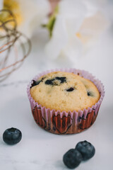 Homemade blueberry muffins baked to perfection on cooling rack in modern white marble kitchen.