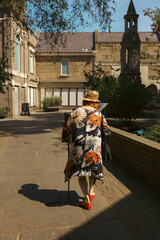Fototapeta na wymiar Older lady walking in Richmond Upon Thames on sunny day