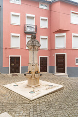 Stone pillory and fountain with old buildings in a square at Penacova, Portugal