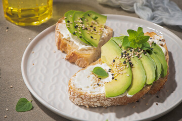 Healthy toast with avocado cream cheese and wheat bread on a plate. Delicious snacks and avocado sandwiches. Food composition, tasty Italian meal.