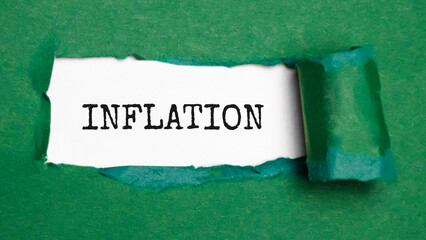 The word inflation is standing on a green background, ripped paper