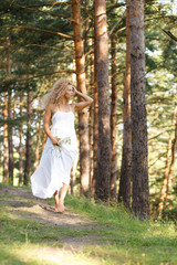 Naklejka premium a girl walks a forest path in summer