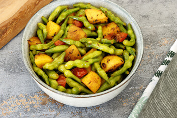 Mogri Aloo Ki Sabzi meal in a bowl. Radish pods with potatoes vegetable dish. Indian cuisine.
