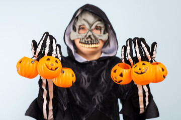 Happy Halloween! Cute little boy in a costume with many pumpkin baskets jack-o-lantern