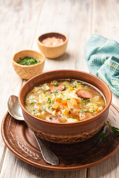 Polish sauerkraut soup Kapusniak in bowl on wooden background