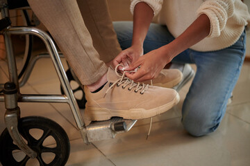 Woman Tying Shoe Laces of Boyfriend